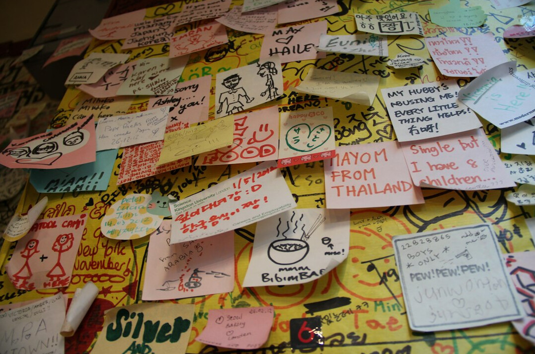 Workshop session with people writing on sticky notes on a glass wall